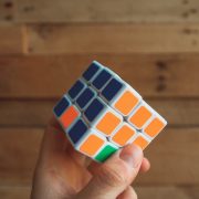 a rubix cube showing a smart person with their hand on the orange and blue part