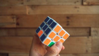 a rubix cube showing a smart person with their hand on the orange and blue part
