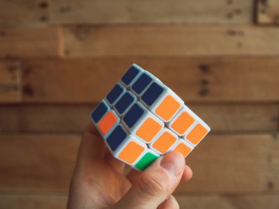 a rubix cube showing a smart person with their hand on the orange and blue part