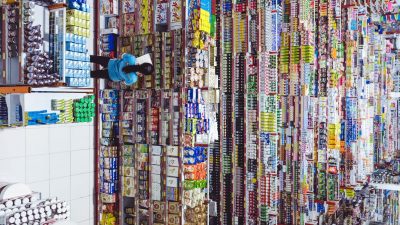 woman standing in front of thousands of products in a store cataloging them