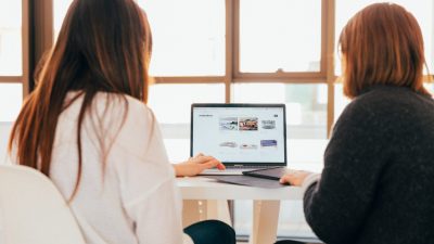 two women looking at an ecommerce shop on a laptop