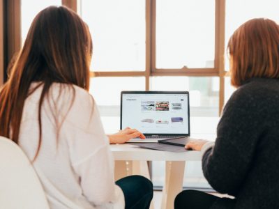 two women looking at an ecommerce shop on a laptop